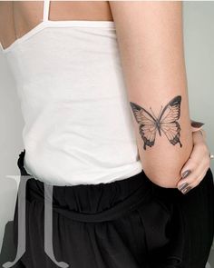 a woman's arm with a butterfly tattoo on the left side of her body