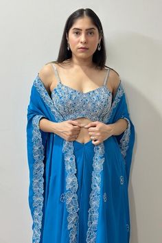 Teal blue cape with cutdana, mirror, kasab embroidered floral cutwork border. Paired with embroidered padded bustier and tulip draped skirt. - Aza Fashions Blue Fitted Palazzo Set With Traditional Drape, Party Blue Choli With Cape Sleeves, Blue Palazzo Set With Unstitched Blouse For Reception, Blue Long Sleeve Choli With Dupatta, Blue Party Sets With Cape Sleeves, Blue Long Sleeve Choli For Reception, Floral Cutwork, Blue Cape, Women Kurta