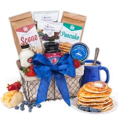 a basket filled with pancakes, blueberries and other items next to a cup of coffee