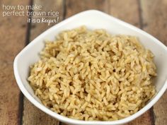 a white bowl filled with brown rice on top of a wooden table