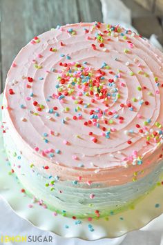 a pink frosted cake with sprinkles on top