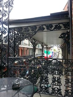 an iron balcony with tables and chairs on it