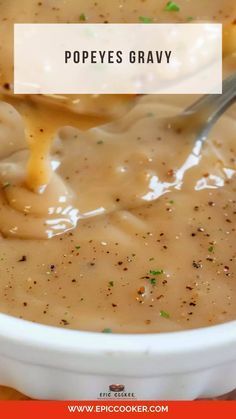 a white bowl filled with soup on top of a wooden table next to a spoon