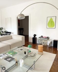 a living room filled with furniture and a glass table on top of a hard wood floor