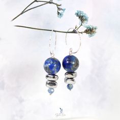 These elegant Lapis Lazuli bead stones dangle drop earrings feature a beautiful deep blue 12 mm Lapis Lazuli beads dangle drop and two painted silver Hematite stone beads, a faceted blue Kyanite tiny bead drop at the end. The beads are on solid 925 sterling silver eye pin, hooked on a diamond cut texture 925 sterling silver ear wire. Add these elegant Lapis Lazuli, Hematite and Kyanite beads dangle drop earrings to your everyday fine jewelry collection or as a gift for your loved one. Materials: 925 sterling silver, Lapis Lazuli, UV hematite, kyaniteDimensions: 1.84 x 0.46 in Jewelry Care: See more information about how to care for your jewelry here. Shipping Policy: Orders will be shipped within 1-3 business days. Economy shipping will take 7-14 days to arrive and standard shipping is 1- Agate Earrings With Natural Stones In Round Beads Shape, Gemstone Beads Dangle Earrings Gift, Gemstone Beaded Dangle Earrings For Gift, Dangle Beaded Earrings With Gemstone Beads As Gift, Gift Gemstone Beaded Dangle Earrings, Elegant Adjustable Beaded Earrings With Gemstone Beads, Elegant Gemstone Beaded Earrings For Gift, Blue Gemstone Bead Drop Earrings, Blue Gemstone Beads Drop Earrings