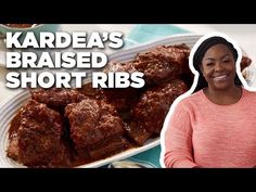 a woman standing in front of a plate of short ribs with sauce on it and the words kaldea's raised short ribs