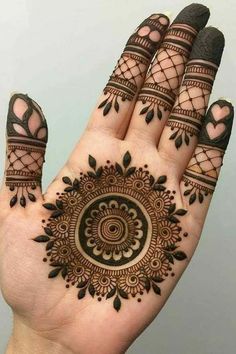 a hand with henna tattoos on it and two fingers in the shape of a circle