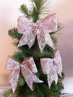 a small christmas tree with pink bows on it