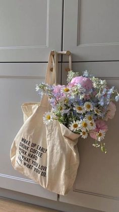 a tote bag with flowers hanging from the handle on a door way hanger