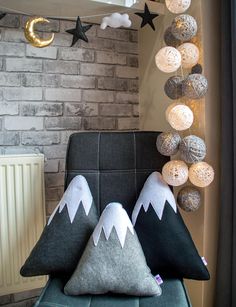 two pillows on a chair in front of a brick wall with stars and moon decorations