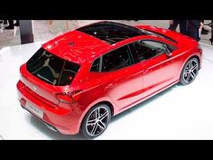 a red car is on display at an auto show