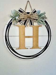 the letter h is made out of wood and decorated with greenery