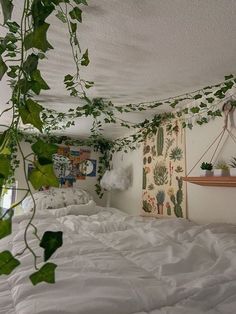 an unmade bed with plants hanging from the ceiling