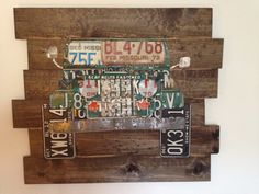 a wooden pallet with license plates mounted to it's sides and hanging on the wall