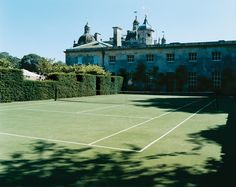 a tennis court in front of a large building