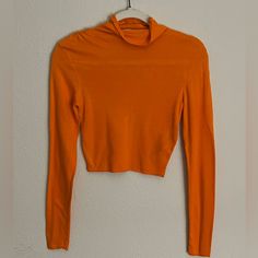 An Orange, Long-Sleeved, Turtle Neck Crop Top; Runched Design Across Both Shoulders, Runs Smaller; Never Worn Orange Stretch Long Sleeve Sweater, Orange Long Sleeve Stretch Sweater, Chic Orange Long Sleeve Sweater, Spring Stretch Turtleneck Blouse, Orange Tops For Workwear In Fall, Orange Tops For Fall Workwear, Fitted Turtleneck Blouse For Spring, Orange Workwear Tops For Fall, Fitted Orange Tops For Work