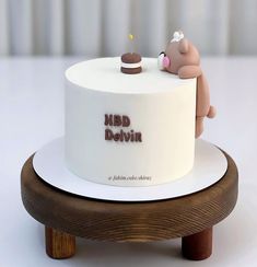 a white cake with two small brown bears on it's top and the words m & d belvin written in red