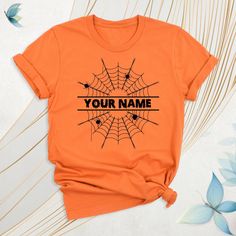 an orange t - shirt with a spider web on it that says, your name