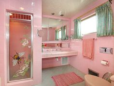 a bathroom with pink walls and tile floors