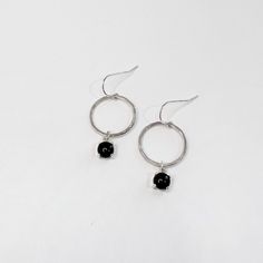 These earrings feature sterling silver wire that has been hand forged into a circle and hammered for a unique texture.  An onyx gemstone has been prong set and is hanging from the circles.  These earrings are simple, dainty, and make a great pair of everyday earrings. Earrings have sterling silver ear wires. Earrings hang just over 1 inch. Display is not included. All products are made to order, please allow up to 1 week before shipping.  Contact Hello@MetrixJewelry.com if you require expedited service. Gemstone Drop Earrings, Rose Quartz Earrings, Hammered Sterling Silver, Onyx Earrings, Onyx Gemstone, Rose Quartz Gemstone, Everyday Earrings, Etsy Earrings Dangle, A Circle