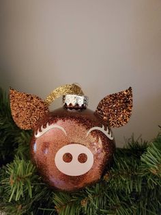 a christmas ornament with a pig face on it's head and ears