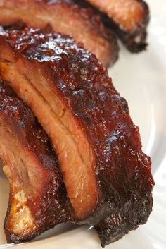 two pieces of meat sitting on top of a white plate