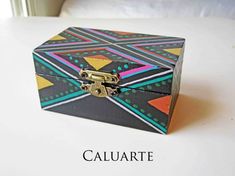 a colorful box sitting on top of a white table next to a window with the word caluarte written below it