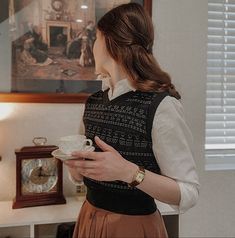 a woman holding a cup and saucer in her hands