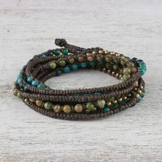 With a bohemian style this wrap bracelet is designed and crafted by Thai artisan Tiraphan Hasub. She hand-braids three strands of polyester cord beaded with gleaming brass serpentine and natural unakite. The bracelet closes with an adjustable button clasp accentuated with ringing bells. Boho Jewelry Diy Bohemian, Accessories Board, Crystals Healing Properties, Jewelry Making Kit, Beads Bracelet Design, Beaded Wrap Bracelets, Popular Jewelry, Beaded Wraps, Hippie Jewelry