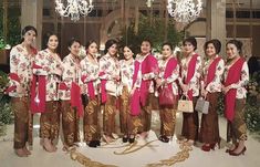 a group of women standing next to each other in front of a chandelier