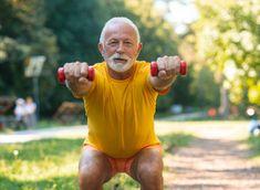 an older man is doing exercises with dumbbells in the park on a sunny day