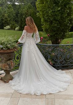 a woman in a wedding dress standing on a balcony