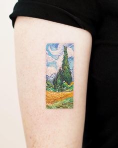 a painting on the back of a woman's arm with a tree in it