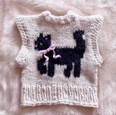 a knitted sweater with a black cat on it