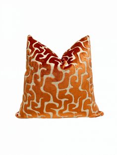 an orange and white pillow on a white background