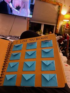 an open notebook with blue origami pieces attached to it and the words i love you because