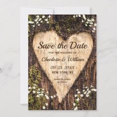 save the date card with a heart cut out from wood and white flowers on it