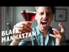 a man holding a wine glass in his hand with the words black manhattan on it