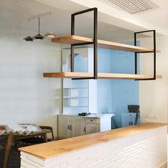 an empty room with some shelves on the wall and other furniture in the back ground