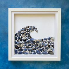 a blue wall with a white frame holding a paper cut out of a sea animal