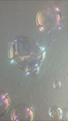 soap bubbles floating in the air on a white surface