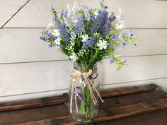 a glass vase filled with purple and white flowers