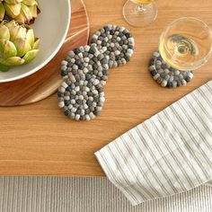 a wooden table topped with plates and bowls filled with food next to glasses of wine