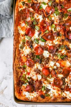 a pizza sitting on top of a pan covered in cheese and pepperoni toppings