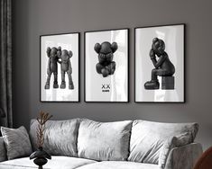 three black and white pictures hang on the wall above a couch