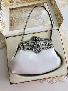 A gorgeous Erickson Beamon white satin evening bag, boxed, used, in great vintage condition. Couple of tiniest dots on the surface. Could be removed from cleaning.  In antique gold hardware, crystal pastes and faux pearls decorating frames.  One pearl missing .  This sweet little evening bag is just right for your fabulous party , Very romantic and super glamorous, prefect for wedding, party.  Measurements: 14x 9cm. Luxury Victorian Silver Bags, Vintage Party Clutch With Pearl Handle, Formal Vintage Evening Bag With Pearl Handle, White Handheld Evening Bag, Vintage Formal Clutch With Pearl Handle, Victorian Clutch Bag For Wedding, Vintage White Party Bags, White Vintage Party Bag, Vintage Clutch Evening Bag For Events