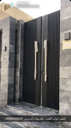 two black doors are open in front of some steps and walls with metal bars on them