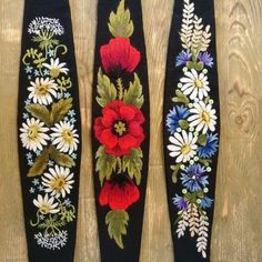 three different types of flowers on black fabric with white and red flowers in the center