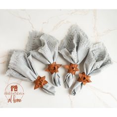 four pieces of cloth with bows on them sitting on a marble counter top next to each other