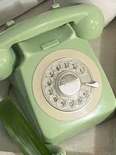 an old green phone sitting on top of a counter